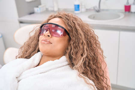 Woman lying on a couch wearing goggles