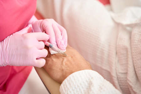 Woman hands with syringe injected beauty injection into patient hand