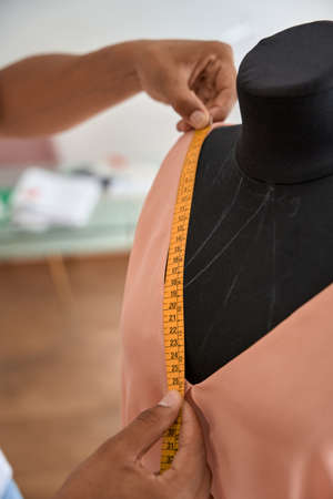 Male tailor doing measurements for new dressの写真素材