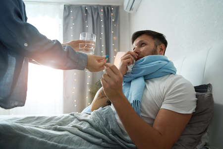 Sick man taking medicine for a mild cold