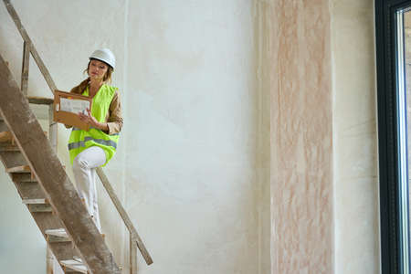 Manager woman climbs wooden stairs to second floorの写真素材