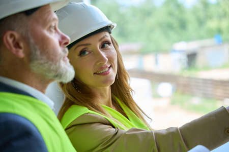 Close-up photo of faces of smiling female realtor and foremanの写真素材