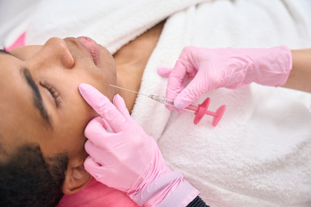 Beauty clinic doctor performing mesotherapy procedure on young man