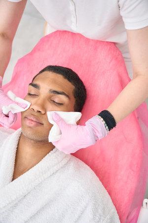 Aesthetic clinic physician preparing young person for cosmetic procedureの写真素材