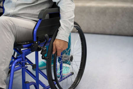 Caucasian man hand is holding a wheelchair