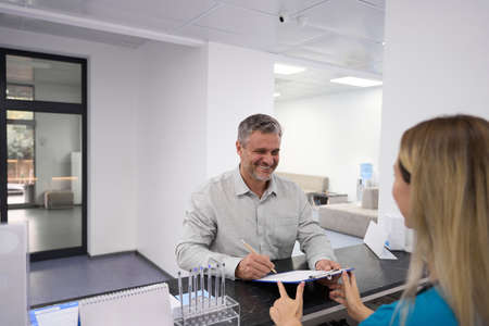 Man filling out paperwork in the hospitalの写真素材