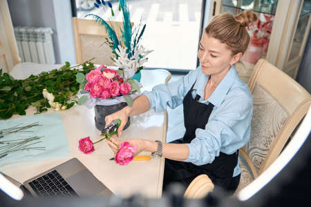 Adorable florist teaches to create flower bouquets in online classの写真素材