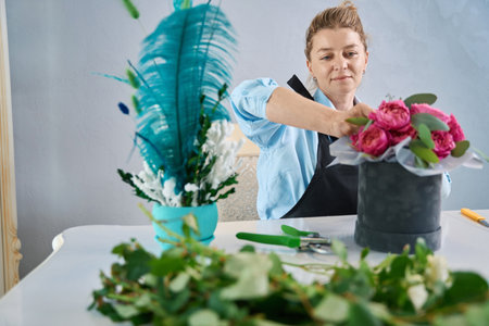 Charming female shop owner makes arrangement of flowers. Master classの写真素材