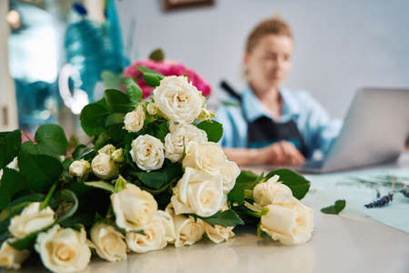 Close-up of a bouquet of small roses with florist on the backgroundの写真素材