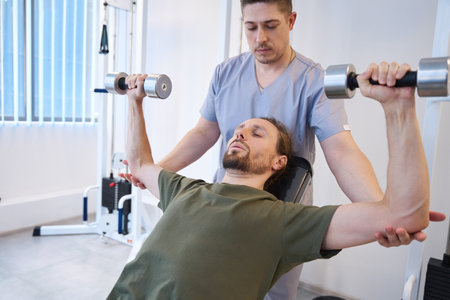 Soldier performs exercises with dumbbells under the supervision of instructorの写真素材