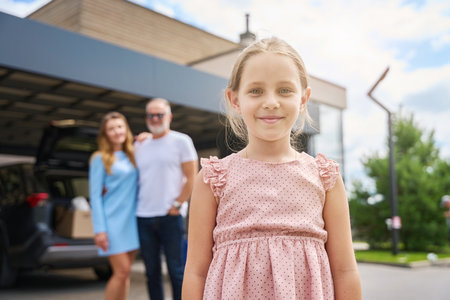 Girl in front of new house, parents are standing behindの写真素材