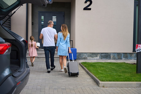 Parents and child carry boxes for moving to new homeの写真素材