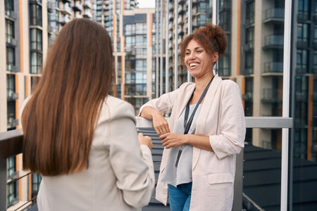 Cheerful corporate employee talking to her coworker outdoorsの写真素材