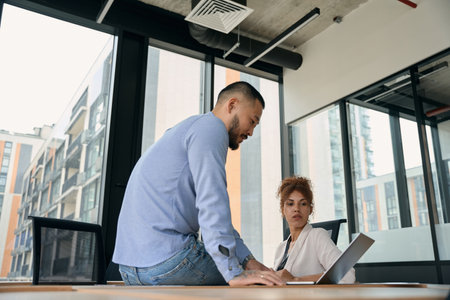 Two office workers sitting at portable computer