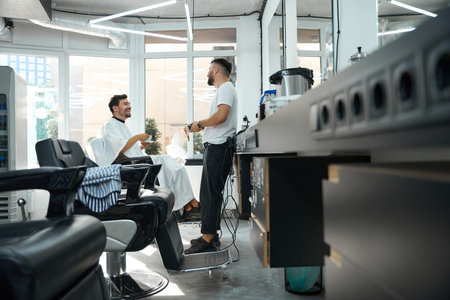 Contented young man enjoying his hairstyle appointment at modern barbershopの写真素材