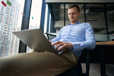 Focused company worker working on his laptopの写真素材
