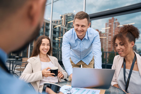 Multiethnic team of corporate workers brainstorming on office balcony
