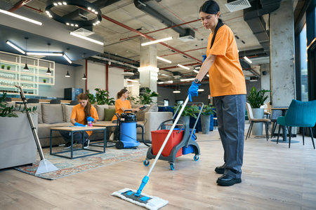 Employees cleaning company performs general cleaning of a coworking spaceの写真素材