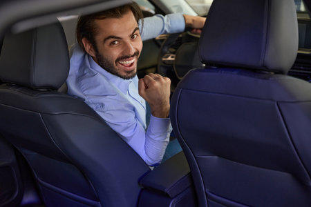 Joyful driver posing for camera in luxury carの写真素材