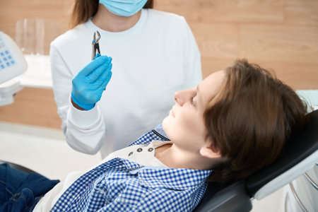 Boy looks at a special tool for tooth extractionの写真素材