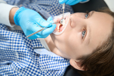 Dentist checks condition of the boy teeth in protective glovesの写真素材