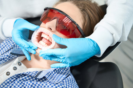 Teenager in a dental chair in special protective glassesの写真素材