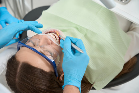 Doctor performing hand scaling procedure on female patient
