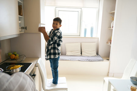 Concentrated male child helping with housework at the weekendの写真素材