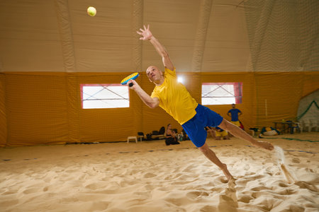 Man hits a tennis ball before it hits the sandの写真素材