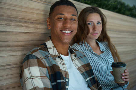 Happy man sitting next to his female colleague