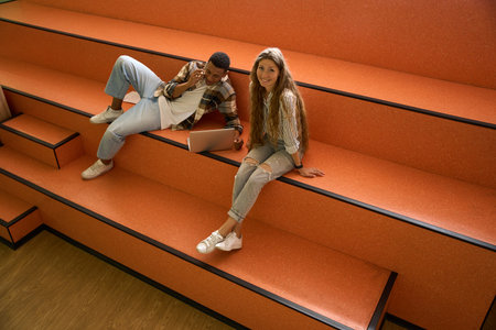 Happy students are sitting on steps together