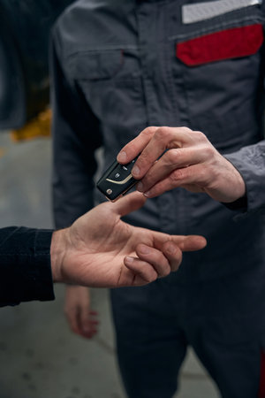 Portrait of male giving car keys after repair