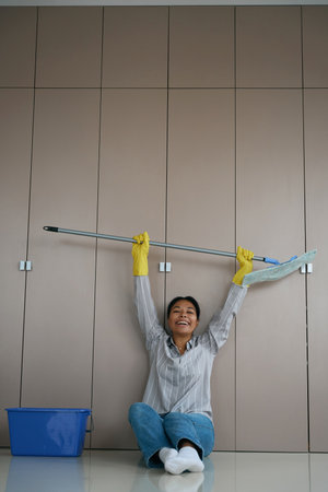 Laughing african american female is sitting on floor near closetの写真素材