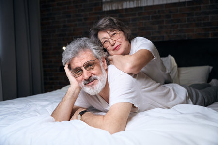 Portrait of old happy couple resting in bedの写真素材