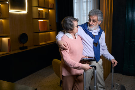 Pleasant mature couple in the hotel lobby waiting for registration