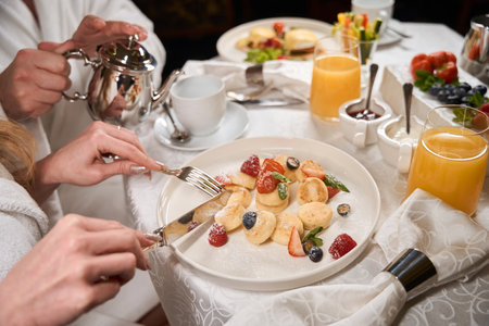Woman is eating fruit salad with cutleryの写真素材