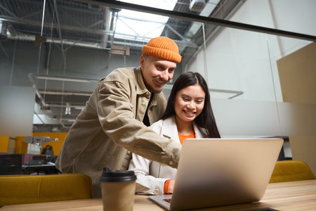 Friendly office worker explaining something to his female colleagueの写真素材