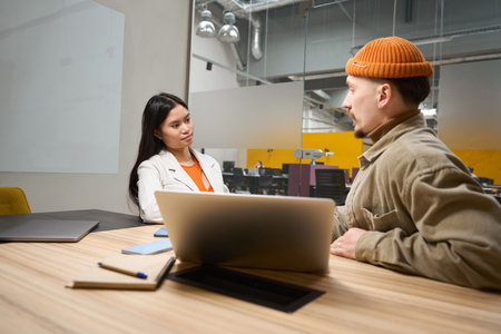 Two office workers communicating in meeting roomの写真素材