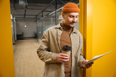 Concentrated corporate employee dealing with paperwork during coffee breakの写真素材