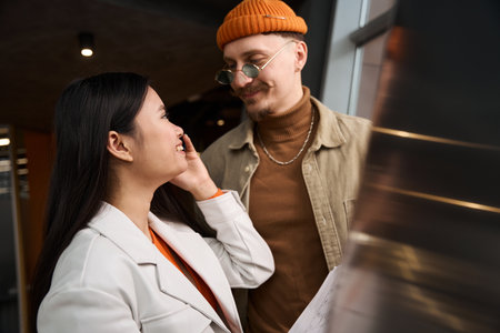 Cheerful businesswoman talking on cellphone in presence of her companionの写真素材