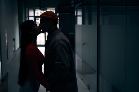 Couple giving kiss to each other in office buildingの写真素材