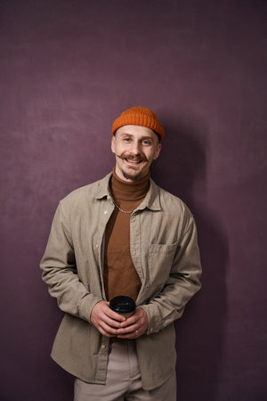 Cheerful guy posing for camera during coffee breakの写真素材
