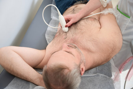 Doctor doing heart ultrasound to adult male patient in clinicの写真素材