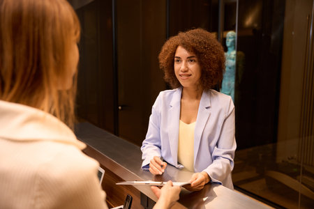 Elegant business woman filling form at counterの写真素材