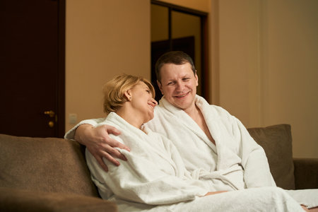 Couple are comfortably located in recreation area of hotel roomの写真素材