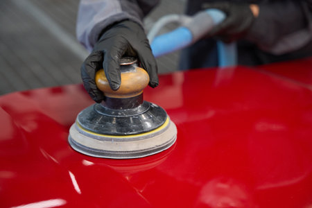 View of person hands polishing car with orbital polisher