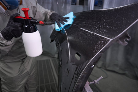 Professional technician detailing car body in garageの写真素材