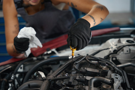Car mechanic in protective gloves checks the oil level in carの写真素材