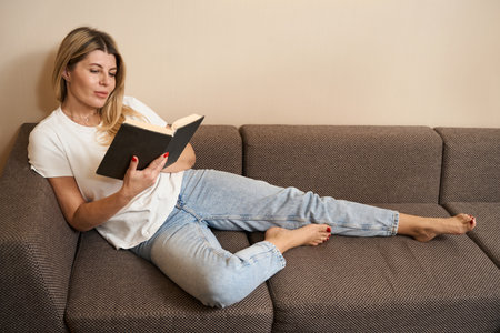 Caucasian pretty woman reading book at living room