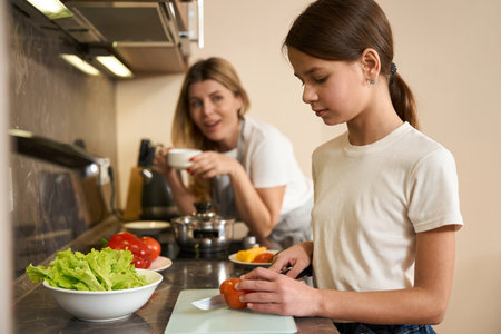 Cropped photo cute girl learning to cook breakfast for familyの写真素材